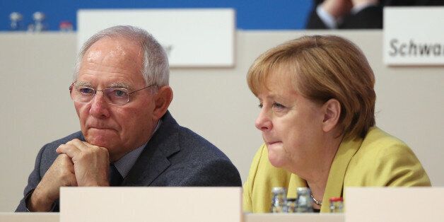 COLOGNE, GERMANY - DECEMBER 10: German Chancellor and Chairwoman of the German Christian Democrats (CDU) Angela Merkel (R) and German Finance Minister Wolfgang Schaeuble chat at the annual CDU party congress on December 10, 2014 in Cologne, Germany. The CDU is the senior partner in Germany's ruling government coalition and yesterday delegates re-elected Merkel as party chairwoman with 96.7% of votes. (Photo by Sean Gallup/Getty Images)