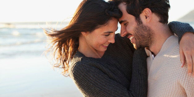 Smiling couple hugging on beach