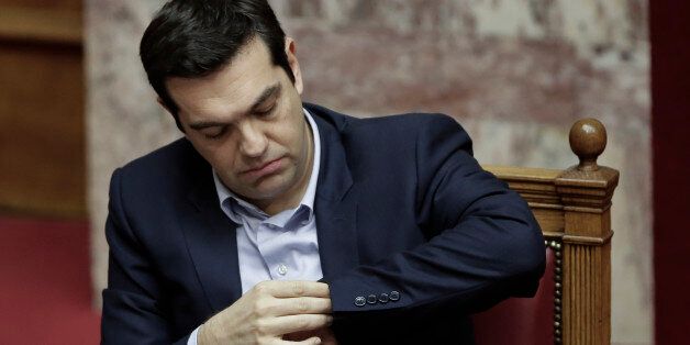 Greece's Prime Minister Alexis Tsipras looks at his watch during a parliament session in Athens, on Tuesday, March 10, 2015. Tsipras spoke during a special debate on whether to revive a parliamentary committee that would seek German World War II reparations that Greece says were never fully paid. The committee would also seek the return of a forced loan raised by Nazi occupation forces, and of Greek antiquities removed during the war.(AP Photo/Petros Giannakouris)
