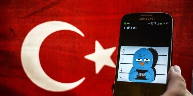 A picture representing a mugshot of the twitter bird is seen on a smart phone with a Turkish flag on March 26, 2014 in Istanbul. A Turkish court on Wednesday overturned the government's controversial Twitter ban imposed after audio recordings spread via the social media site implicated Prime Minister Recep Tayyip Erdogan in a corruption scandal. AFP PHOTO / OZAN KOSE (Photo credit should read OZAN KOSE/AFP/Getty Images)