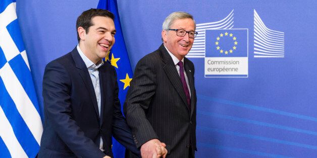 European Commission President Jean-Claude Juncker, right, walks hand in hand with Greece's Prime Minister Alexis Tsipras upon his arrival at the European Commission headquarters in Brussels Wednesday, Feb. 4, 2015. Tsiparis is on a one day trip to Brussels to meet with EU leaders. (AP Photo/Geert Vanden Wijngaert)