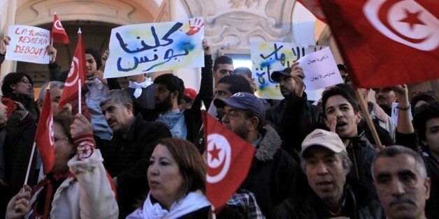 TUNIS, TUNISIA - MARCH 18: A group of people hold banners and shout slogans during a protest against a terrorist gunmen attack at the Bardo Museum, on March 18, 2015 in front of the Tunisian National Theater in Tunis, Tunisia. Terrorist gunmen opened fire at the Bardo Museum in Tunisia's capital, killing 21 people including 2 gunmen and at least 22 people wounded including tourists, the Tunisian Prime Minister said. (Photo by Yassine Gaidi/Anadolu Agency/Getty Images)