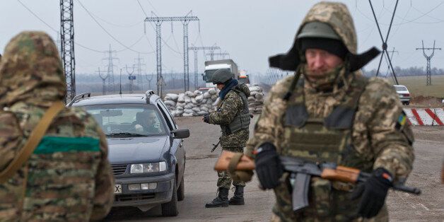In this picture taken on March 3, 2015, a soldier checks a vehicle at an Ukrainian army checkpoint near Kurakhove, Ukraine, just a few miles away from the area controlled by Russia-backed rebels. Restrictions imposed on travel from separatist-controlled areas to the rest of Ukraine, coupled with a recent surge in reports of supply trucks being blocked from sending goods to the separatist zone, underscore the vulnerability of the Russia-backed rebel rule as well as the Ukrainian governmentâs virtual crackdown on its own citizens. (AP Photo/Vadim Ghirda)