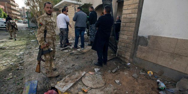Security Personnel inspect the Iranian ambassador's house after it received minor damage from an improvised explosive device placed among garbage bags, in Tripoli, Libya, Sunday, Feb. 22, 2015. Iran's Foreign Ministry spokeswoman Marzieh Afkham condemned the