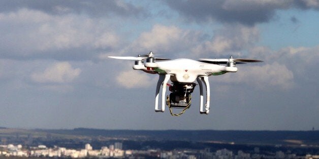 A drone (UAV) is pictured flying over Reims, on February 27, 2015. Investigators in Paris have been left puzzled by a string of drone sightings over Paris, even as three journalists for TV station Al-Jazeera were arrested on February 26, 2015 for flying one from a park on the edge of the city. Witnesses and security forces reported at least five sightings overnight Tuesday to Wednesday and a similar number the night before. AFP PHOTO/FRANCOIS NASCIMBENI (Photo credit should read FRANCOIS