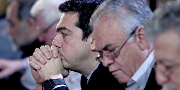 Greek Prime Minister Alexis Tsipras (L) sists next to Deputy Prime Minister Giannis Dragasakis (R) before delivering a speech at the Syriza party headquarters, in Athens on February 28, 2015. Greece's Prime minister vowed Saturday no retreat from his principles in the eurozone country's 'battle' with creditors as he seeks to live up to election promises to reverse austerity cuts and avoid a third bailout. 'The battle will continue,' the far-left Alexis Tsipras told the central committee of his hard-left Syriza party in Athens. 'Anybody thinking that we are going to go away will be disappointed.' AFP PHOTO / Angelos Tzortzinis (Photo credit should read ANGELOS TZORTZINIS/AFP/Getty Images)