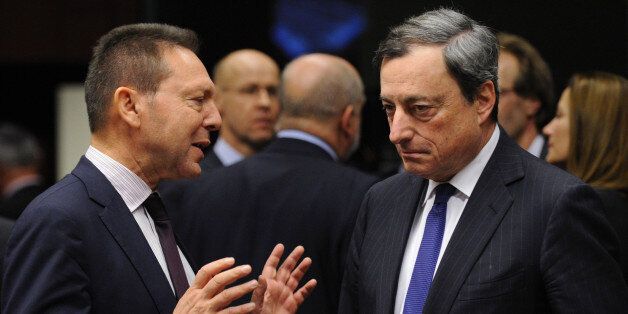 Greek Finance Minister Yannis Stournaras (L) speaks with European Central Bank (ECB) president Mario Draghi before a Eurogroup Council meeting at EU Headquarters in Brussels on December 17, 2013. AFP PHOTO/JOHN THYS (Photo credit should read JOHN THYS/AFP/Getty Images)