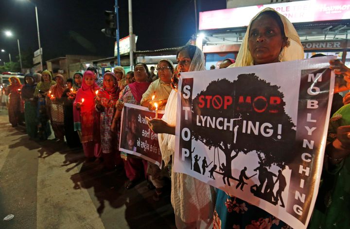 Women hold placards and candles during a protest against the mob lynchings across the country, in Ahmedabad, India, June 27, 2019.