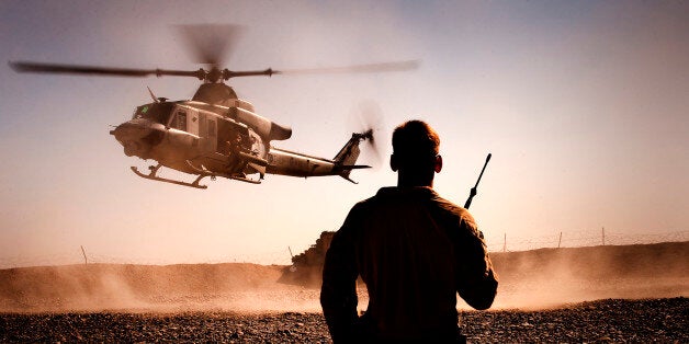 FORWARD OPERATING BASE GERONIMO, Helmand province, Islamic Republic of Afghanistan â Cpl. Michael Lyons, the 3rd Battalion, 3rd Marine Regiment, air noncommissioned officer, monitors the inbound descent of an AH-1W SuperCobra onto the Forward Operating Base Geronimo landing zone in Afghanistan, Nov. 7, 2010. The helicopter transported Marine Light Attack Helicopter Squadron 369âs senior leadership to FOB Geronimo to attend a plaque dedication ceremony in honor of Lt. Col. Mario D. Carazo and Maj. James M. Weis, two pilots from HMLA-369 who were killed in action while supporting 3/3 combat operations in July. (Official Marine Corps photo by Sgt. Mark Fayloga)