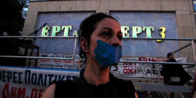 A protester with her mouth tapped takes part in a protest in solidarity to the employees of Greek state broadcaster ERT, in Thessaloniki Greece, on Friday, June 21, 2013. Greece's fragile coalition government was left bruised but standing after a junior party decided to pull its two ministers from the cabinet following a falling-out over the unpopular closure of state broadcaster ERT. Democratic Left pulled out of Prime Minister Antonis Samaras' year-old coalition, withdrawing two cabinet minist