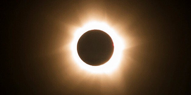 In this photo provided by Tourism Queensland, the moment of a total solar eclipse is observed at Cape Tribulation in Queensland state, Australia, Wednesday, Nov. 14, 2012. Starting just after dawn, the eclipse cast its 150-kilometer (95-mile) shadow in Australia's Northern Territory, crossed the northeast tip of the country and was swooping east across the South Pacific, where no islands are in its direct path. (AP Photo/Tourism Queensland) EDITORIAL USE ONLY