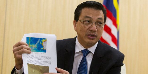 Malaysian Transport Minister Liow Tong Lai explains a weekly report on the missing Malaysia Airlines Flight 370 during an interview ahead of the one-year anniversary of the plane's disappearance, in Putrajaya, Malaysia on Saturday, March 7, 2015. If the massive undersea search for Malaysia Airlines Flight 370 turns up nothing by the end of May, the three countries leading the effort will re-examine data and come up with a new plan, Lai said Saturday. (AP Photo/Joshua Paul)