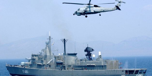 The Greek frigate Navarino, and a helicopter, conduct a security exercise on the Saronic Gulf, south of Athens, Wednesday, Aug. 4, 2004. Teams of frogmen, helicopters and warships of Greek Navy took part in an exercise in preparation for the Aug.13-29 Olympics, when they will be deployed at several ports. (AP Photo/Petros Giannakouris)
