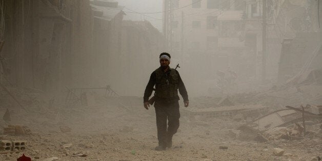 DAMASCUS, SYRIA - FEBRUARY 23: A Syrian opposition member is seen at a street where many buildings are destroyed after Assad regime forces' barrel bomb attack hit the Syrian opposition controlled area in Daraa district of Aleppo, Syria on February 23, 2015. (Photo by Stringer/Anadolu Agency/Getty Images)