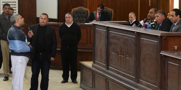 Qatar-based Al-Jazeera English journalist Egyptian-Canadian Mohamed Fahmy (L) adresses the judge at the courtroom in Cairo during his retrial on February 12, 2015. An Egyptian court ordered the release of two Al-Jazeera journalists pending their retrial for allegedly supporting the banned Muslim Brotherhood. Fahmy was ordered to pay bail of 250,000 Egyptian pounds ($33,000) while Egyptian Baher Mohamed was released on his own recognisance along with other defendants. AFP PHOTO/ MOHAMED EL-SHAHE