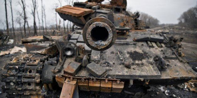 A destroyed tank is abandoned on the road at a former Ukrainian army checkpoint that was overran last month by Russia-backed separatists during the offensive for Debaltseve, outside the city of Chornukhyne, Ukraine, Monday, March 2, 2015. More than 6,000 people have died in eastern Ukraine since the start of the conflict almost a year ago that has led to a