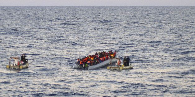 In this file photo taken on Thursday, Dec. 4, 2014 provided by the Italian Navy, rescue crews approach migrants on a rubber boat some 40 miles (65 kilometers) from the Libyan capital, Tripoli. Rescue crews discovered 16 bodies in a migrant boat off Libya, the first reported deaths since the European Union took over Mediterranean rescue operations, the Italian navy said Friday. Migrants dreaming of Europe have their pick of social media sites that work like an online travel agent, advertising fares and offering tips on secure payments. Meanwhile, the traffickers who send them floating across the Mediterranean are buying scrapyard cargo ships over the Internet. (AP Photo/Italian Navy, file)