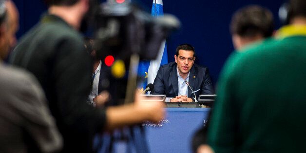 Greek Prime Minister Alexis Tsipras, center, speaks during a media conference after an EU summit in Brussels on Thursday, Feb. 12, 2015. European Union leaders on Thursday said the full respect of the planned weekend cease-fire in eastern Ukraine will be essential before there could be a change in the sanctions regime imposed on Moscow. (AP Photo/Geert Vanden Wijngaert)