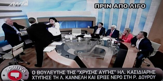 In this image taken off a TV screen, Ilias Kasidiaris, 2nd left, spokesman of Greece's extremist far-right Golden Dawn party, who was elected to Parliament in the country's recent inconclusive polls physically assaults Liana Kanelli, a female member of the Parliament for the Greek Communist party during a talk show at the studios of the ANTENA TV station in Athens on Thursday, June 7, 2012. Kasidiaris bounded out of his seat and slapped Communist Party member Liana Kanelli three times on Thursda