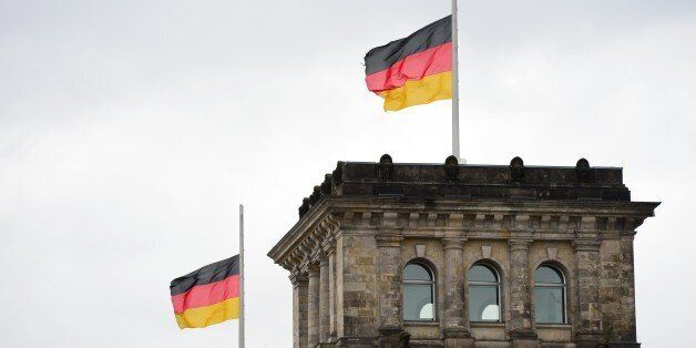 German flags fly at half mast on the roof of the Reichstag building housing the lower house of parliament Bundestag in Berlin on January 9, 2015, in commemoration of the victims of an Islamist attack by armed gunmen on the offices of French satirical newspaper Charlie Hebdo in Paris on January 7, which left 12 dead and many others injured. AFP PHOTO / JOHN MACDOUGALL (Photo credit should read JOHN MACDOUGALL/AFP/Getty Images)