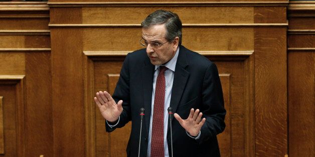 Greece's former Prime Minister Antonis Samaras walks past Greece's Prime Minister Alexis Tsipras, left, during a parliament session before the conference vote in Athens, on Tuesday, Feb. 10, 2015. Greece's newly elected government was due to receive a vote of confidence from the newly-elected parliament late Tuesday, and his ministers insisted they would stick to their election pledges â halting major privatization plans and reversing austerity taxes demanded by bailout lenders.(AP Photo/P