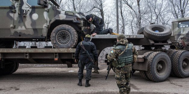 ARTEMIVSK, UKRAINE - FEBRUARY 14: Ukrainian soldiers secure a vehicle to a trailer at a checkpoint along the road toward the embattled town of Debaltseve on February 14, 2015 in Artemivsk, Ukraine. A ceasefire between Ukrainian forces and pro-Russian rebels is scheduled to go into effect at midnight. (Photo by Brendan Hoffman/Getty Images)