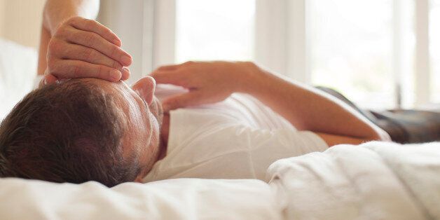 Man laying in bed with head in hands