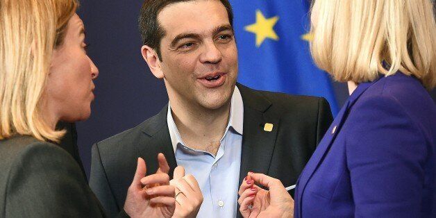 Greek Prime Minister Alexis Tsipras (C) speaks with EU foreign policy chief Federica Mogherini (L), Danish Prime Minister Helle Thorning-Schmidt (R) at a family photo during an European Council leaders summit in Brussels, February 12, 2015. AFP PHOTO/EMMANUEL DUNAND (Photo credit should read EMMANUEL DUNAND/AFP/Getty Images)