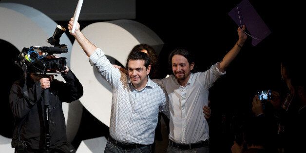 MADRID, SPAIN - NOVEMBER 15: New Podemos Party leader Pablo Iglesias (R) and leader of Greece's left-wing political party Syriza, Alexis Tsipras (L) wave their hands during a meeting to announce the elected Podemos Party members at Nuevo Apolo Theatre on November 15, 2014 in Madrid, Spain. Pablo Iglesias has been elected as general secretary of Podemos Party after gaining 95,311 (88.6 percent) votes through an internet poll. Podemos Party came out from the 'Indignants' and social movements. (Photo by Pablo Blazquez Dominguez/Getty Images)