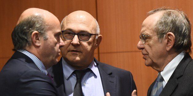 (L-R) Spanish Finance minister Luis de Guindos Jurado, French Finance minister Michel Sapin and Italian Finance minister Pier Carlo Padoan attend an Eurogroup finance ministers meeting at the European Council in Brussels, on February 16, 2015. AFP PHOTO/Emmanuel Dunand (Photo credit should read EMMANUEL DUNAND/AFP/Getty Images)