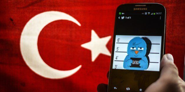 A picture representing a mugshot of the twitter bird is seen on a smart phone with a Turkish flag on March 26, 2014 in Istanbul. A Turkish court on Wednesday overturned the government's controversial Twitter ban imposed after audio recordings spread via the social media site implicated Prime Minister Recep Tayyip Erdogan in a corruption scandal. AFP PHOTO / OZAN KOSE (Photo credit should read OZAN KOSE/AFP/Getty Images)