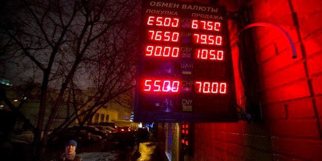 A man walks past an exchange office with a sign advertising currency exchange rates in Moscow, Russia, Tuesday, Jan. 13, 2015. The currency was down more than 4 percent in afternoon trading in Moscow, at around 66 rubles per dollar. The ruble hit a record low of 80 per dollar in mid-December before recovering a bit, but it has been steadily falling since the start of the year. Lines from top indicate the spread on the dollar-ruble rate, the euro-ruble rate, the British pound-ruble rate and the S