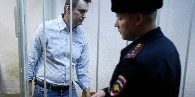FILE - In this Tuesday, Dec. 30, 2014 file photo, Russian opposition activist Alexei Navalny, 38, enters a cage at a court in Moscow, Russia. Russia's leading opposition figure Alexei Navalny has been sentenced to 15 days in police custody for handing out leaflets in the subway. (AP Photo/Pavel Golovkin, File)