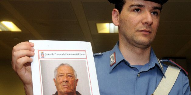 An Italian Carabinieri policeman shows a photo of Gaetano Riina, brother of the Sicilian Mafia's one-time top boss Salvatore