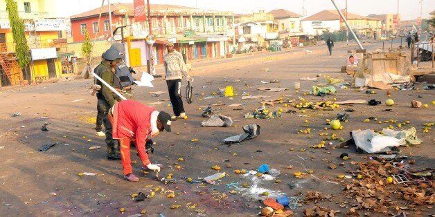 Nigerian security inspect the scene of a bomb blast at the Jos Terminus Market, on December 12, 2014. A double bomb attack that killed 31 people in a crowded market in the central Nigerian city of Jos was likely to have been carried out by Boko Haram, the state government said. 'It's an extension of the terrorist acts that have been penetrating all states and cities,' Pam Ayuba, spokesman for the Plateau state governor Jonah Jang, told AFP by telephone. AFP PHOTO/STRINGER (Photo credit sh