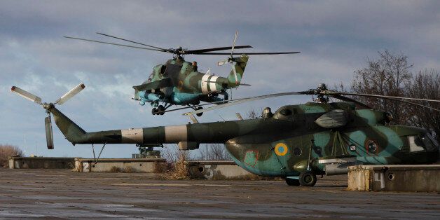 Helicopters seen at a military base of the Ukrainian government army in Kramatorsk, Donetsk region, eastern Ukraine Wednesday, Dec 24, 2014. Peace talks aimed at reaching a stable cease-fire in Ukraine between its government forces and pro-Russian armed groups began on Wednesday in Minsk, Belarus, with the discussions to include a pullout of heavy weapons and an exchange of war prisoners. (AP Photo/Sergei Chuzavkov)