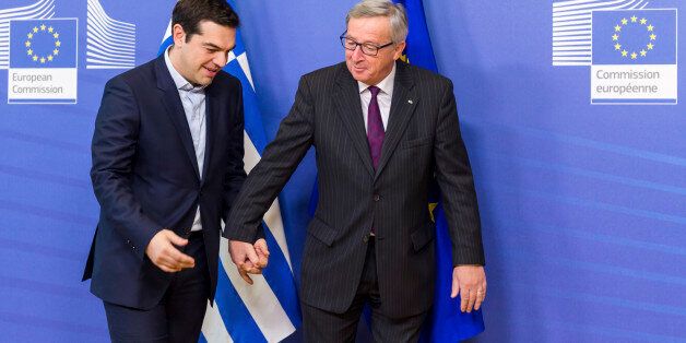 European Commission President Jean-Claude Juncker, right, walks hand in hand with Greece's Prime Minister Alexis Tsipras upon his arrival at the European Commission headquarters in Brussels Wednesday, Feb. 4, 2015. Tsiparis is on a one day trip to Brussels to meet with EU leaders. (AP Photo/Geert Vanden Wijngaert)