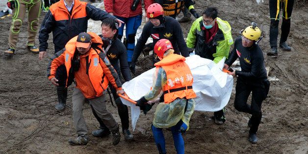 Search and rescue divers carry a recovered body at the site of a commercial plane crash in Taipei, Taiwan, Friday, Feb. 6, 2015. TransAsia Airways Flight 235 with 58 people aboard clipped a bridge shortly after takeoff and crashed into a river in the island's capital of Taipei on Wednesday morning. (AP Photo/Wally Santana)