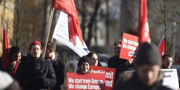 Protestors hold a sign reading 'We start from Greece, we change Europe' during a demonstration in front of the German Finance minstry ahead of a meeting of Greece's new Finance Minister with his German counterpart in Berlin, on February 5, 2015. Greece's new finance minister Yanis Varoufakis faces tough talks with his German counterpart Wolfgang Schaeuble after the European Central Bank piled fresh pressure on Athens by restricting Greek banks' access to much-needed cash. AFP PHOTO / ODD ANDERSEN (Photo credit should read ODD ANDERSEN/AFP/Getty Images)