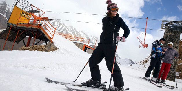 In this Friday, Jan. 16, 2015 photo, a female Iranian skier prepares to descend from a slope at the at the Shemshak ski resort in the Alborz mountain range 36 miles (60 kilometers) northeast of the capital Tehran, Iran. With quite steep slopes at an altitude of 2550m to 3050m above sea level, lighting facilities for night skiing, and a normal ski season from late November to late April, Shemshak attracts many advanced Iranian and foreign skiers. (AP Photo/Vahid Salemi)