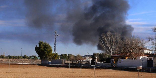 Smoke rises from a military base after a plane crash in Albacete, Spain, Monday, Jan. 26, 2015. A Greek F-16 fighter jet crashed into other planes on the ground during NATO training in southeastern Spain Monday, killing at least 10 people, Spain's Defense Ministry said. Another 13 people were injured in the incident at the Los Llanos base, which sent flames and a plume of black smoke billowing into the air, a Defense Ministry official said. (AP Photo/Josema Moreno)