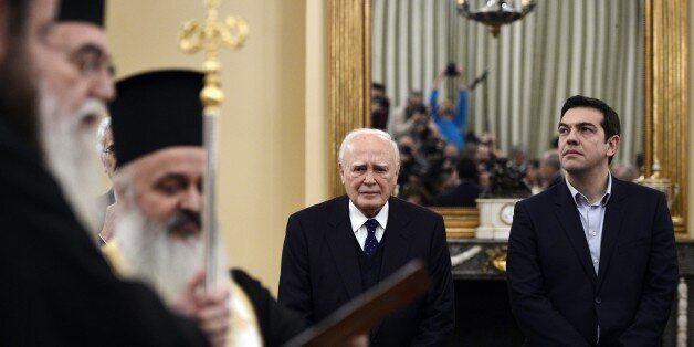 Newly elected Greek Prime Minister Alexis Tsipras (R) and President Carolos Papaoulias look on as the new government's take the civil oath, during a ceremony at the Presidental Palace in Athens, on January 27, 2015. Tsipras, the leader of the Syriza leftist party, has raised fears of a possible Greek exit from the single currency area by vowing to reduce the huge debt payments Greece has to make following its international bailouts. AFP PHOTO / LOUISA GOULIAMAKI (Photo credit should read