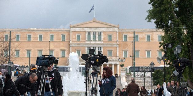 ATHENS, GREECE - JANUARY 25: Media crew set up in front of the Greek Parliament building on January 25, 2015 in Athens, Greece. According to the latest opinion polls, the left-wing Syriza party are poised to defeat Prime Minister Antonis Samaras' conservative New Democracy party in the election, which will take place today. European leaders fear that Greece could abandon the Euro, write off some of its national debt and put an end to the country's austerity by renegotiating the terms of its bailout if the radical Syriza party comes to power. Greece's potential withdrawal from the eurozone has become known as the 'Grexit.' (Photo by Matt Cardy/Getty Images)