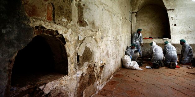 A team of archaeologists and anthropologists take notes after starting the excavation work after identifying three unrecorded and unidentified graves in the chapelâs crypt of the closed order Convent of the Barefoot Trinitarians in Madrid's historic Barrio de las Letras, or Literary Quarter, Spain, Saturday, Jan. 24, 2015. Experts searching for the remains of Miguel de Cervantes hope they may be entering the final phase of their nine-month quest to solve the mystery of where the great Spanish writer was laid to rest. The 'Don Quixote' author was buried in 1616 at the Convent but the exact whereabouts of his grave in the tiny convent chapel are unknown. The bones found will be exhumed and analyze, after that, the experts will try to identify the bones using DNA profiling. (AP Photo/Daniel Ochoa de Olza)