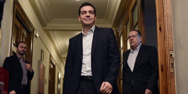 Newly elected Greek Prime Minister Alexis Tsipras (C) arrives on January 28, 2015 for his first cabinet meeting at the Greek Parliament in Athens. Greece's new radical left-led government prepared to meet on January 28 for the first time to hammer out a strategy for renegotiating the country's giant bailout, after storming to power on a promise to reject years of harsh austerity policies. AFP PHOTO / LOUISA GOULIAMAKI (Photo credit should read LOUISA GOULIAMAKI/AFP/