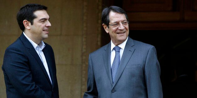 Cyprus' president Nicos Anastasiades, right, shakes hands with Greek Prime Minister Alexis Tsipras at the Presidential Palace following their meeting in the capital Nicosia, Monday, Feb. 2, 2015. Tsipras is visiting Cyprus, his first trip abroad as prime minister since his election last month. It's customary for all newly-elected Greek prime ministers to conduct their first trip abroad to Cyprus because of the two countries' deep historic ties. (AP Photo/Petros Karadjias)
