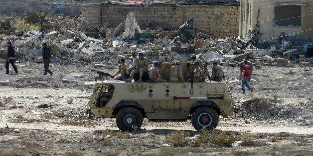 RAFAH, GAZA - NOVEMBER 01: An armoured vehicle of Egyptian army is seen as they blow up buildings as part of an operation aiming to create a buffer zone at the Rafah border in Egypt, on November 1, 2014. After a bombing attack that killed 30 people in the North Sinai region, Egyptian army launched an operation to prevent attacks at the Rafah border which is between Gaza strip and Egypt. (Photo by Abed Rahim Khatib/Anadolu Agency/Getty Images)