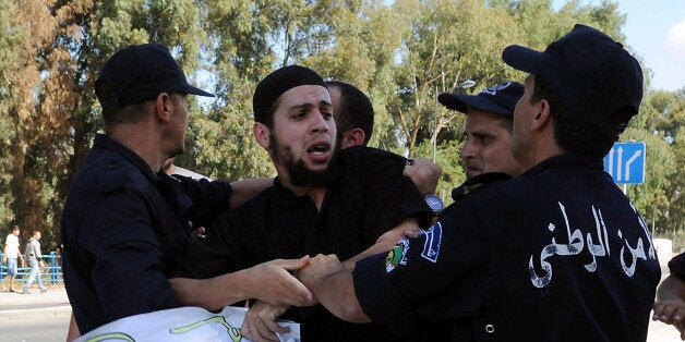 Algerian policemen arrest a demonstrator during a protest against an amateur film mocking Islam in Algiers on September 14, 2012. Anti-US protests by crowds whipped into fury by a film that mocks Islam erupted across the Muslim world, as violence exploded in Sudan, Lebanon, Tunisia and Yemen leaving five dead and dozens injured. AFP PHOTO/FAROUK BATICHE (Photo credit should read FAROUK BATICHE/AFP/GettyImages)