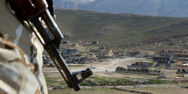 In this Sunday Jan. 11, 2015 photo, a Yazidi fighter protects the Sharaf al-Deen temple shrine, one of the holiest for the Yazidis, a religious minority whom the Islamic State group considers heretics ripe for slaughter, in Sinjar, northern Iraq. Kurdish forces have taken back a large part of Sinjar since the Sunni extremists occupied it in August last year. The shrine came under attack at least 16 times during the Islamic State onslaught, local fighters say, but the Yazidis held the line with h