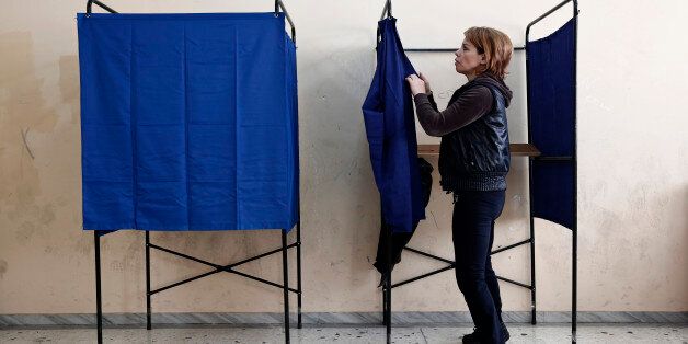 A municipal worker assembles voting booths at a voting center, in Athens, Friday, Jan. 23, 2015. Prime Minister Antonis Samaras' New Democracy party has failed so far to overcome a gap in opinion polls with the anti-bailout Syriza party ahead of the Jan. 25 general election. (AP Photo/Petros Giannakouris)